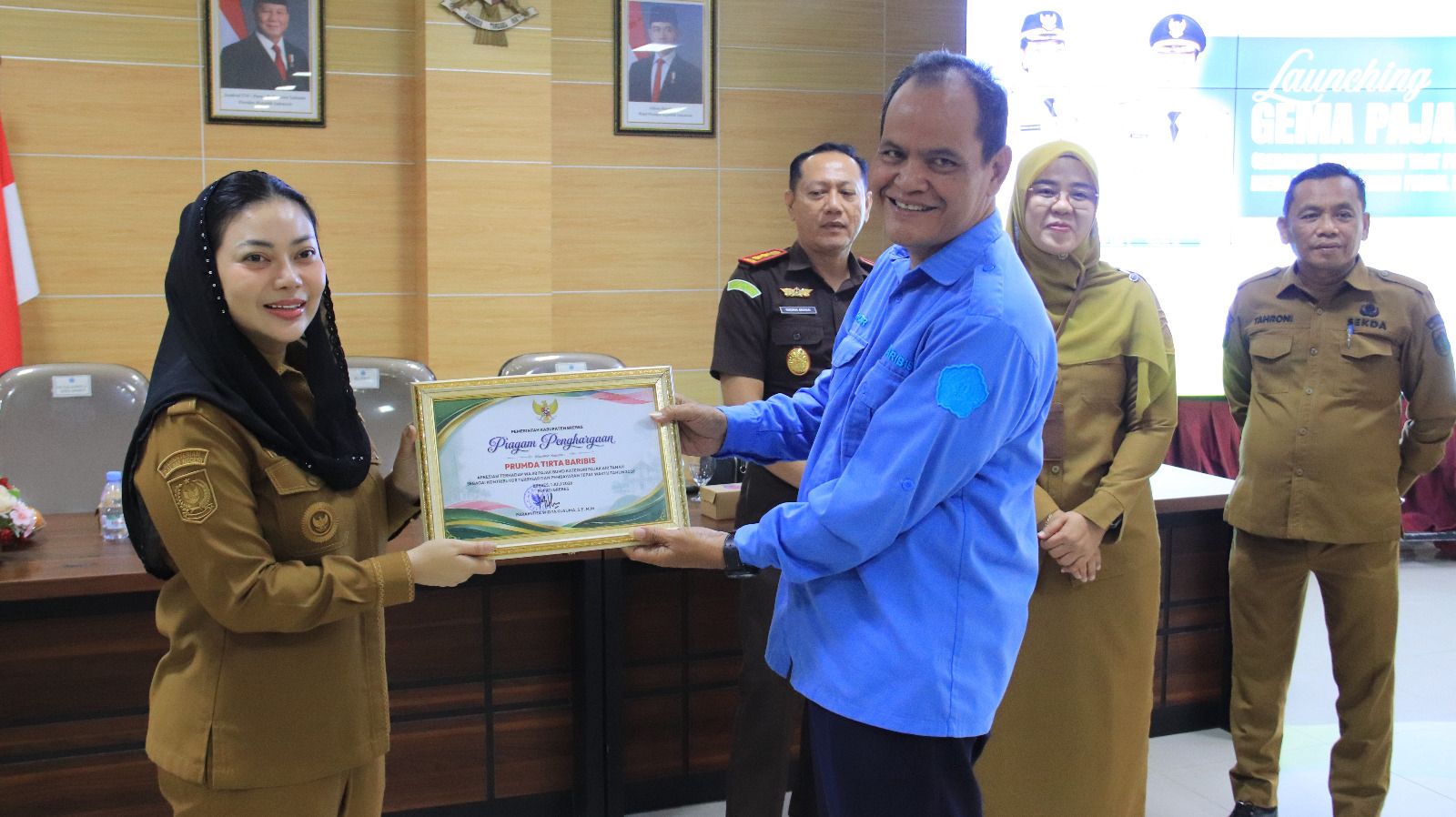 Bupati Brebes, Paramitha Widya Kusuma menyerahkan Piagam Penghargaan kepada Perwakilan Perumda Air Minum Tirta Baribis, Kepala Satuan Pengawas Intern (SPI) Abdul Ghofur, Sebagai Wajib Pajak BUMD Kategori Pajak Air Tanah dengan Kontributor Terbesar dan Pembayaran Tepat Waktu Tahun 2026.